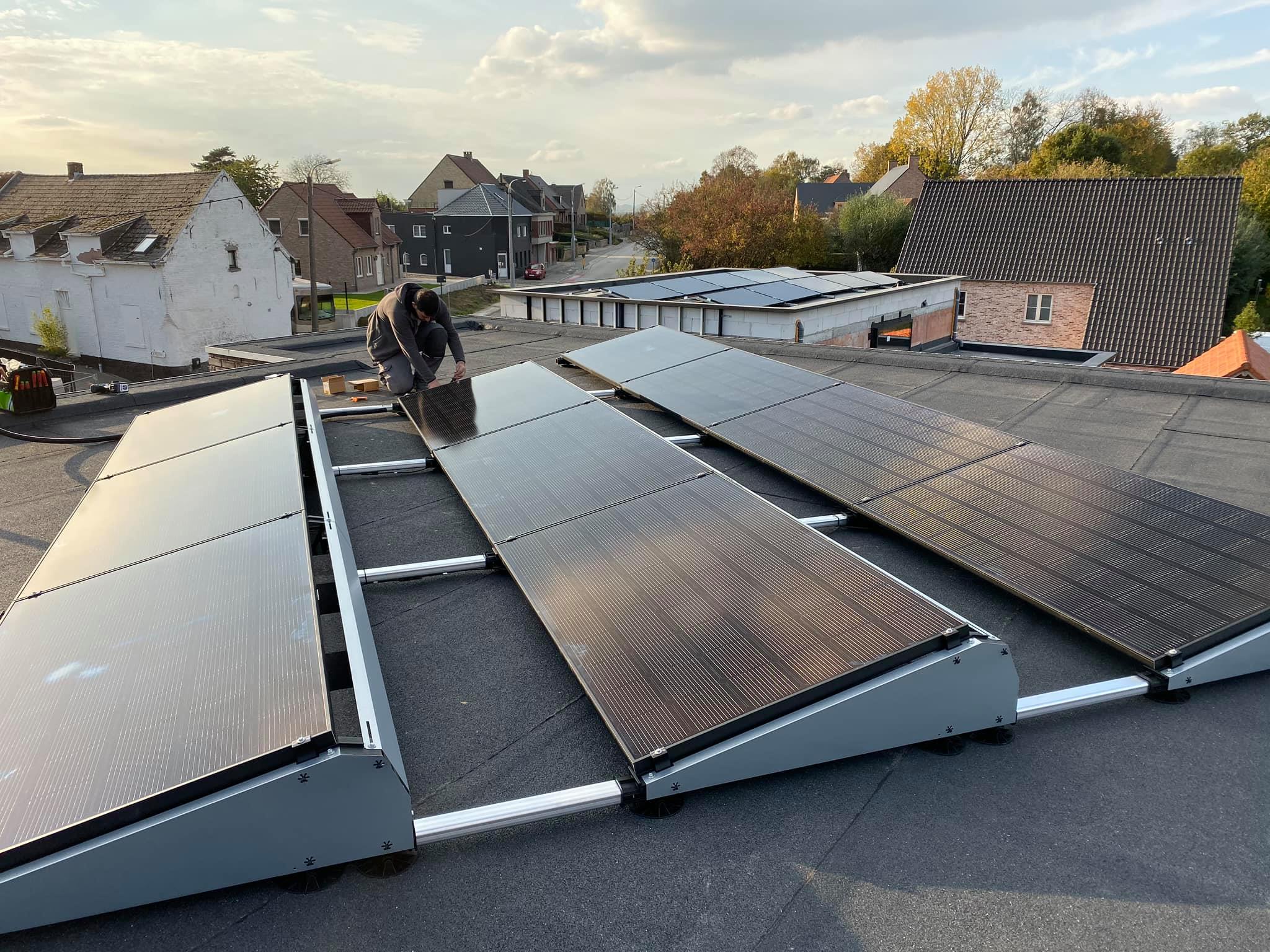 elektricien van electro pacco installeert zonnepanelen op plat dak in sedelgem voor duurzame energie