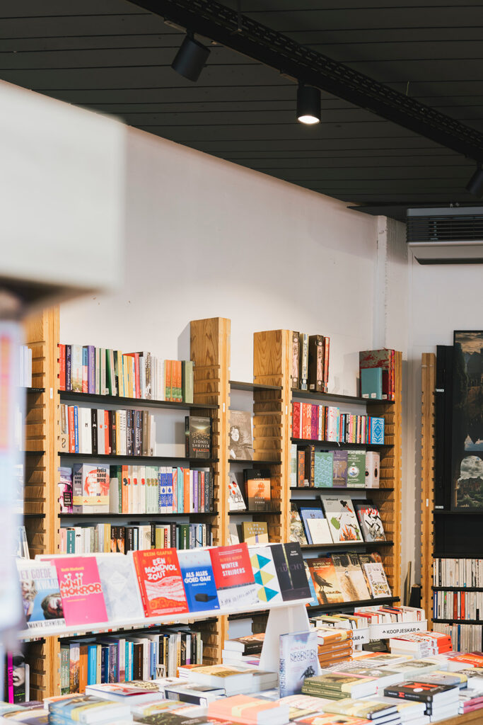 plafondspot verlichting in bibliotheek boven houten boekenrekken met diverse boeken