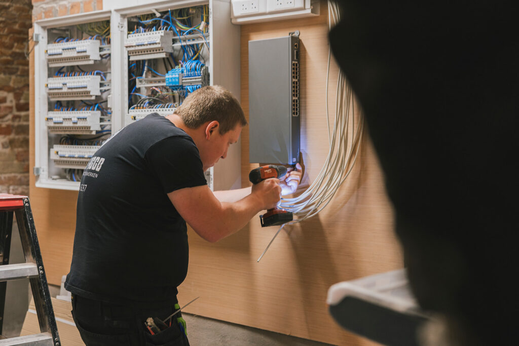 elektricien van Electro Pacco installeert bedrading en schakelaars in een technische ruimte in Zedelgem