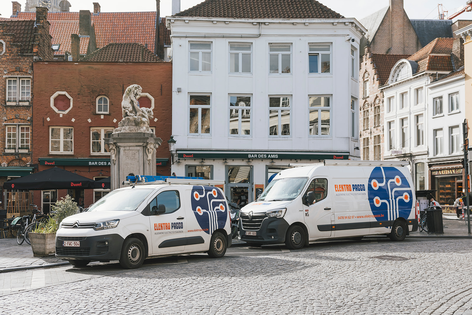 elektro pacco bedrijfswagens geparkeerd op historisch plein met oude gebouwen op de achtergrond