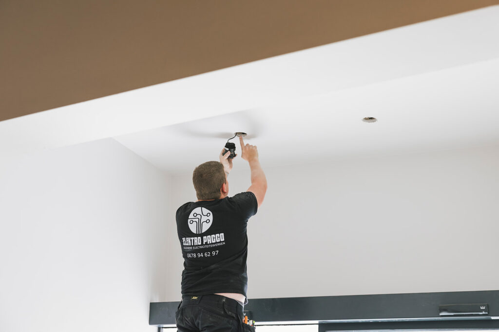 elektricien van elektro pacco installeert led-verlichting in wit plafond in zedelgem