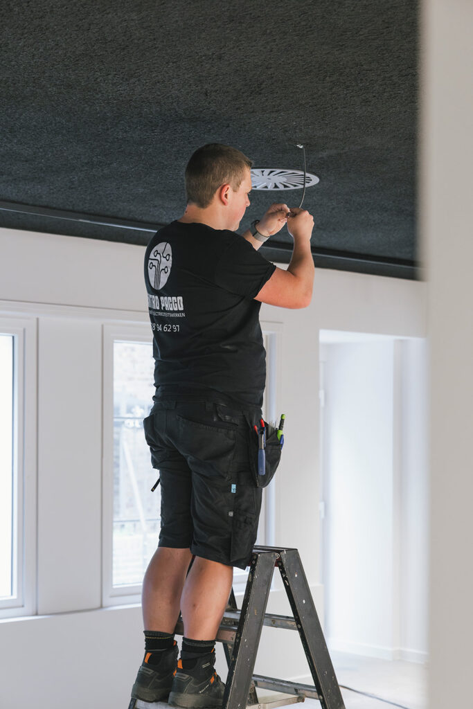 elektricien van electro pacco monteert bedrading aan het plafond in woning in zedelgem