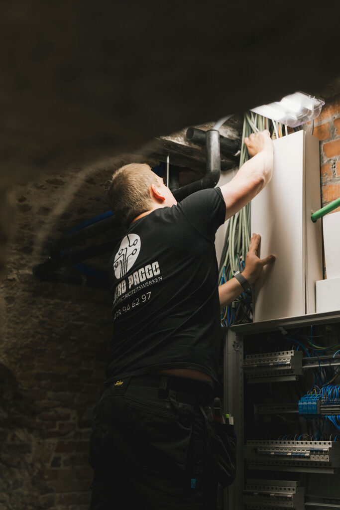 elektricien van electro pacco werkt aan een elektrisch paneel in een kelderruimte in zedelgem