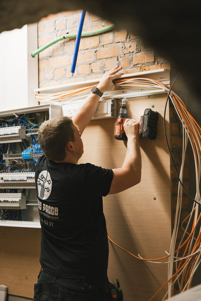 elektricien monteert bekabeling en schakelkast met boormachine elektro pacco zedelgem