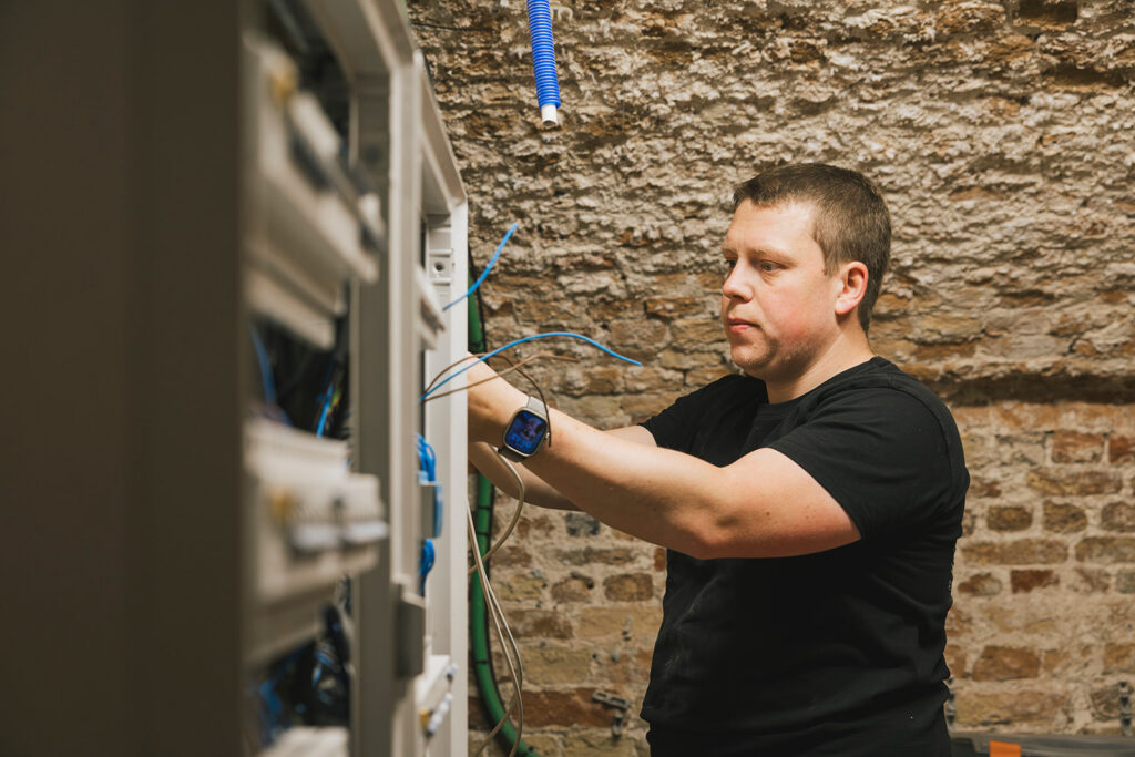 elektricien van electro pacco werkt aan een elektriciteitskast in oude ruimte in zedelgem