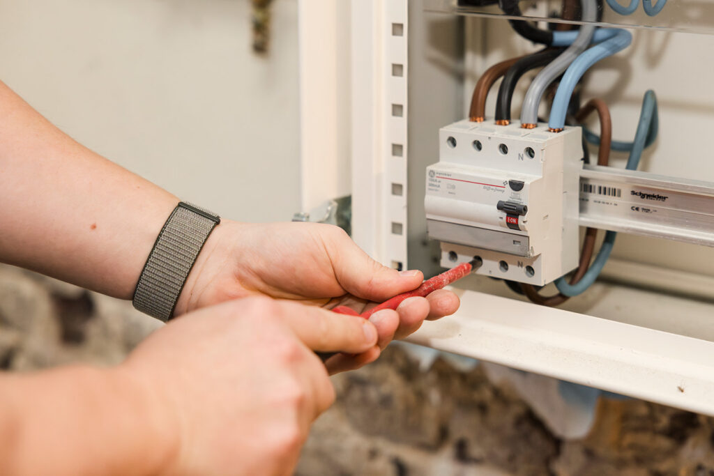 elektricien werkt met schroevendraaier aan elektrische zekeringkast van electro pacco in zedelgem