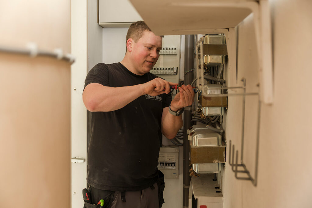 elektricien van electro pacco werkt aan elektrische bedrading in meterkast