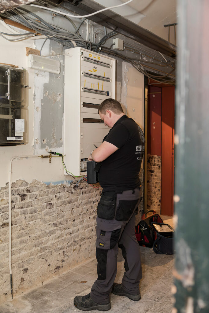 elektricien van electro pacco werkt aan een groepenkast in een oude kelder in zedelgem