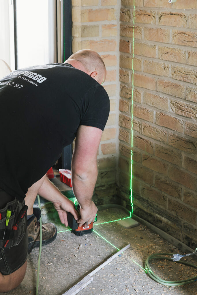 elektricien van electro pacco gebruikt laserwaterpas voor nauwkeurige installatie in woning