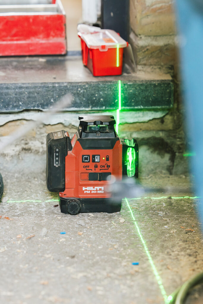 rode hilti pm 30-mg laser waterpas met groene lichtlijn op bouwplaats door electro pacco