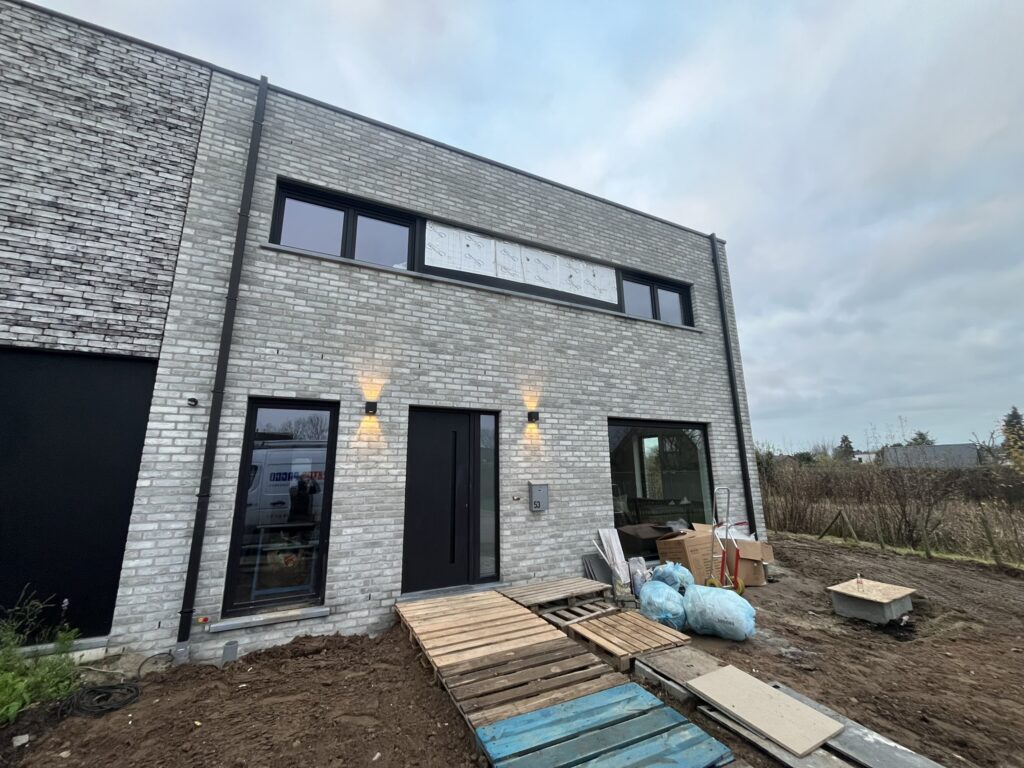 moderne gevel met zwarte ramen verlichting en bouwmaterialen voortuin elektro pacco sedelgem