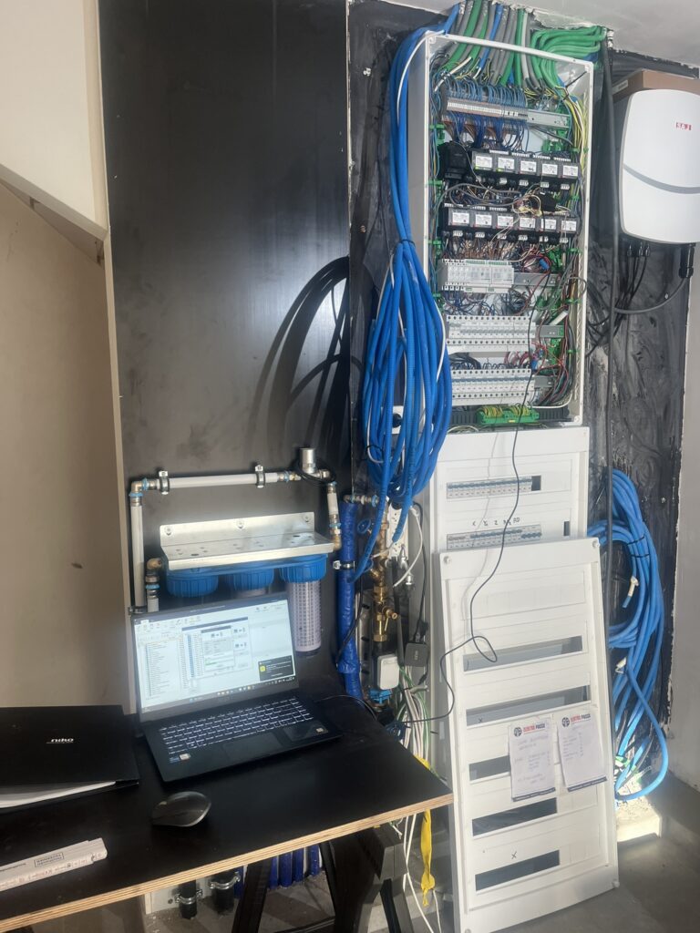 elektriciteitskast met blauwe kabels en laptop in werkomgeving electro pacco zedelgem
