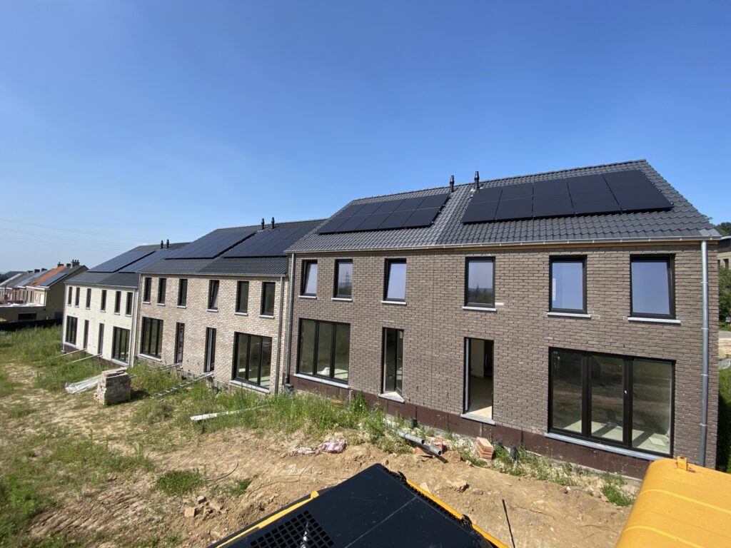 nieuwbouwwoningen met zwarte zonnepanelen op het dak onder een heldere blauwe lucht elektro pacco zedelgem